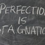 lavagna con scritto perfection is stagnation