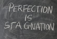 lavagna con scritto perfection is stagnation