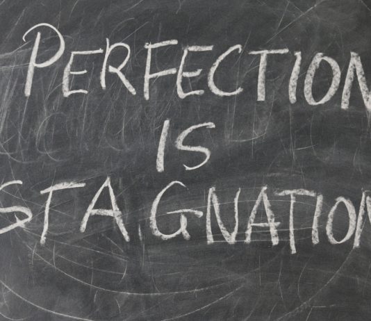 lavagna con scritto perfection is stagnation