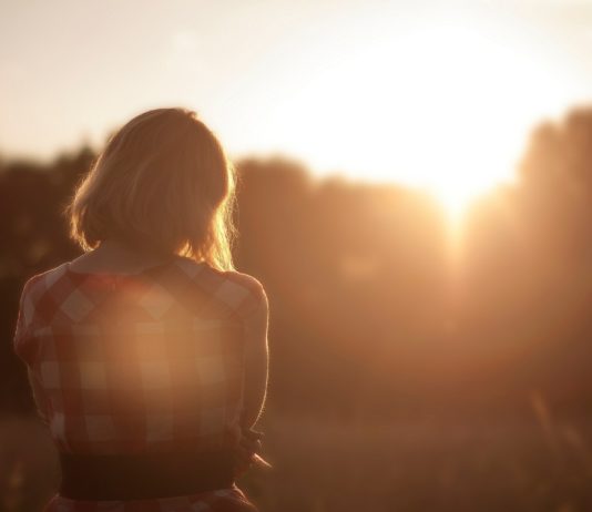 donna di spalle che guarda il tramonto