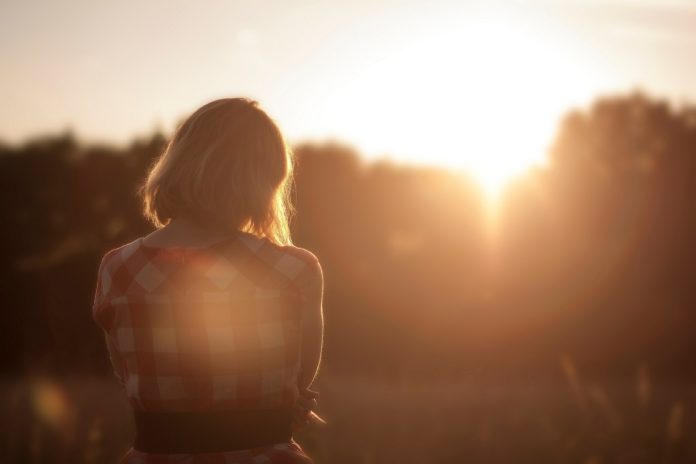 donna di spalle che guarda il tramonto