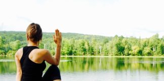 donna in posizione yoga in riva al lago