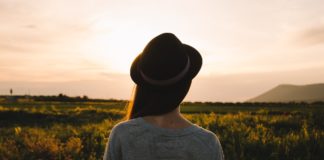 donna con cappello che guarda l'orizzonte