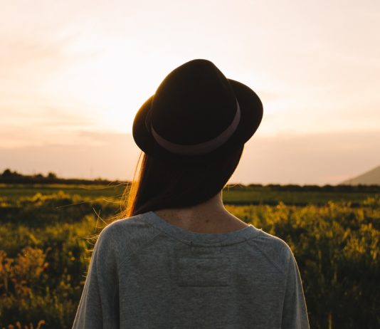 donna con cappello che guarda l'orizzonte