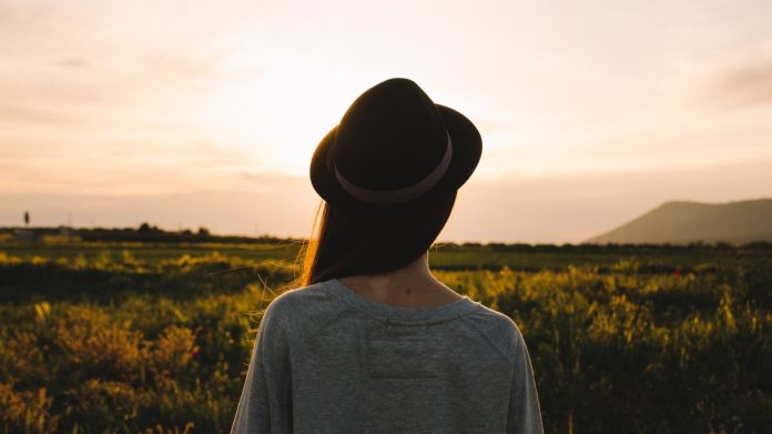 donna con cappello che guarda l'orizzonte