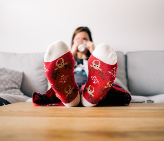 donna sul divano con i piedi sul tavolo