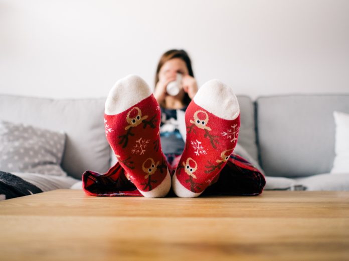 donna sul divano con i piedi sul tavolo