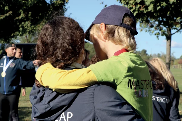 Abbraccio tra partecipanti del Master CAP all’aperto, simbolo di connessione e sostegno reciproco.