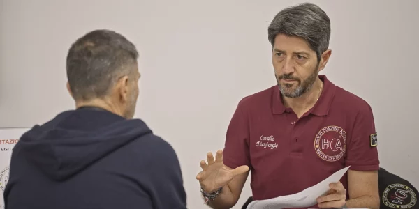 Medico HCA che parla con un coachee durante un colloquio individuale di presa in carico.